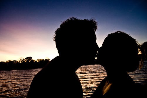 couple kissing sunset. kissing behind a sunset